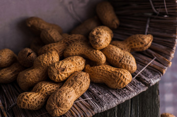 Peanuts in nutshell on a piece of wood