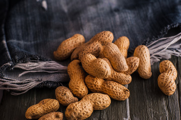 Peanuts in nutshell on a piece of wood