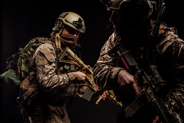soldiers or private military contractors holding rifle. Image on a black background. war, army,...