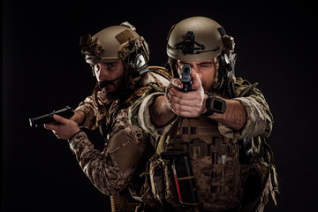 soldiers or private military contractors holding rifle. Image on a black background. war, army,...