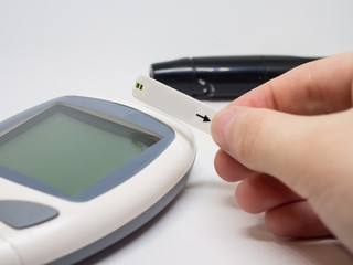 Woman's hand. children's hands doing sugar test on a glucometer isolated on white background