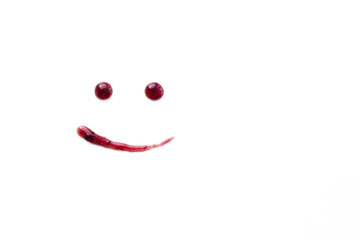 Drawing smile of berry jam on white