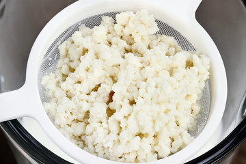 Fresh Kefir grains in strainer. Kefir is one of the top health foods available providing powerful probiotics. It is cultures of yeast and bacteria use to make a fermented milk product.