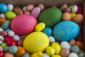 Fototapeta na wymiar Colorfull Easter Eggs in the wooden box with sweet candies.