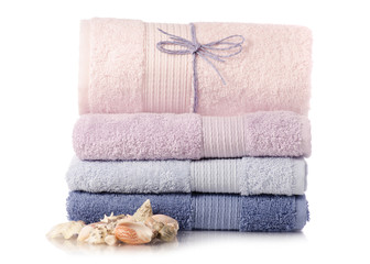 Fototapeta na wymiar A stack of towels pink blue spa sea seashell stones