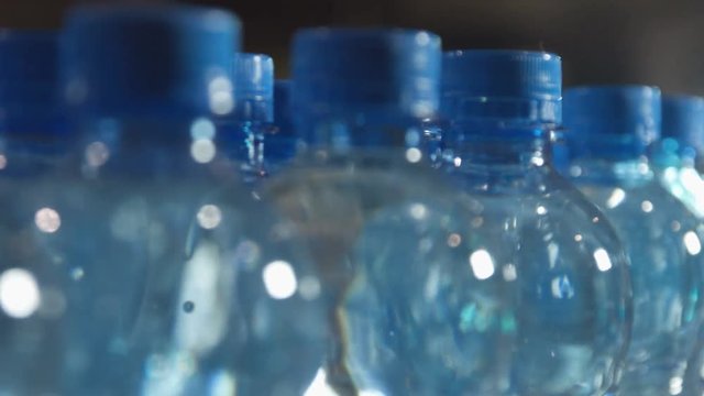 plastic bottles full of water with a blue cap on the production line