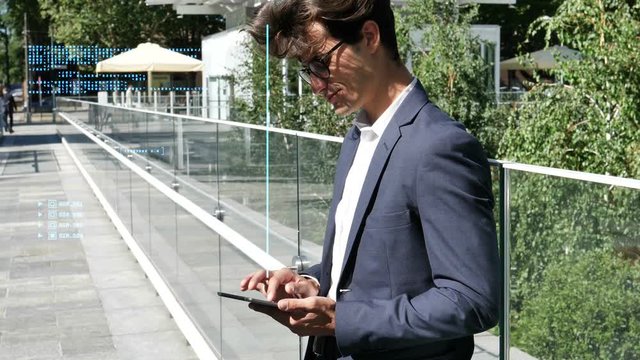 Handsome eleganty young business man using tablet computer, with animated transparent code appearing next to him, outdoor