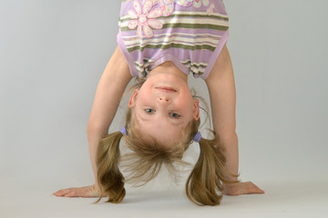 Little girl standing on her hands.