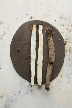 Cut salsify roots on a ceramic plate and old painted board as background