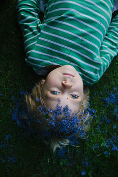 Little girl with Lilac petals on her head plays at dusk.
