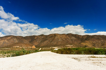 the road on mountain plateau, green mountains against the blue sky