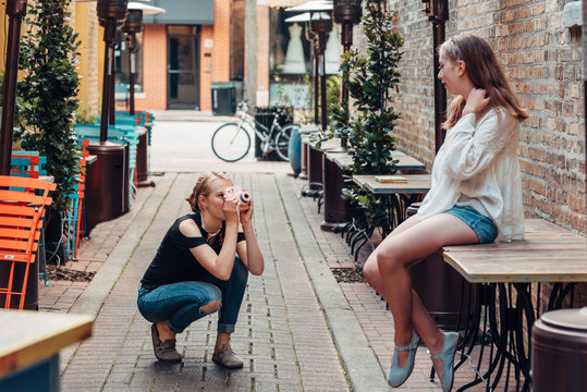 Two friends taking photos in an alley