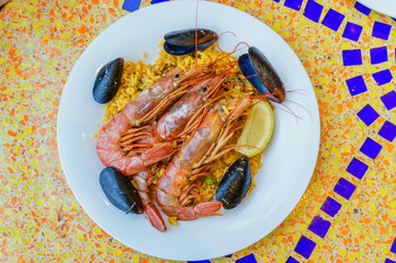 paella portion, rice with tiger shrimps, mussels and lemon