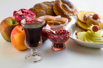 Rosh Hashanah,Traditional Jewish New Year concept.Symbolic foods are honey,apple,pomegranete and juices.Close up taken,isolated.