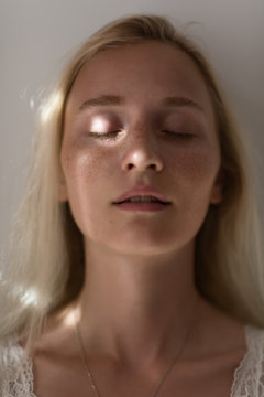 Blond woman with eyes closed