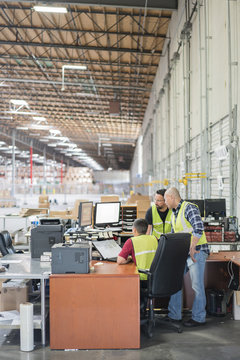 Warehouse workers at a computer station.