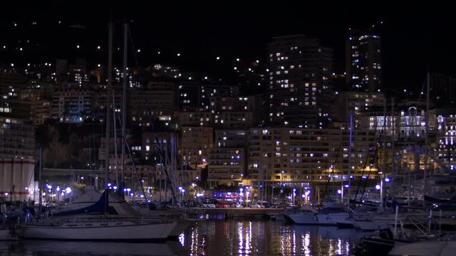 Boats and buildings at night in Monaco