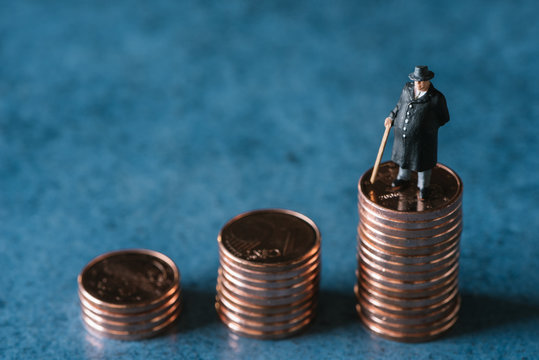 Business figurine standing on stack of coins