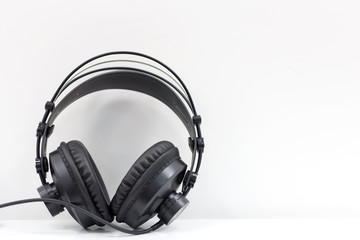 Fototapeta na wymiar Headphone hanging on a white wall. Music background. Audio equipment