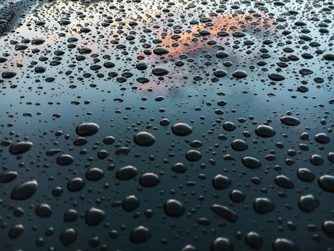 Many Water Drops on blue surface of a car