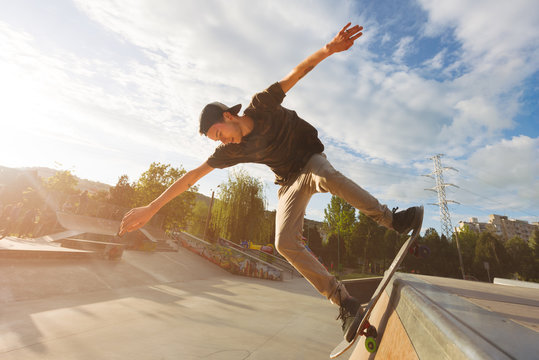 Portrait of male teenager riding skateboard on wooden ramp
