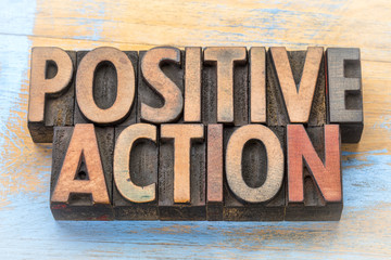 positive action - word abstract in wood type