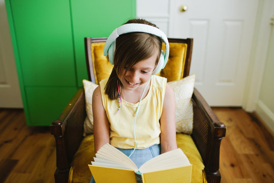 Young girl reading along while listening to a book