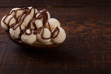 Chocolate egg with filling for Easter on wooden background