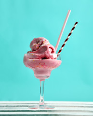 Pink strawberry Ice-cream dessert in martini glass with straw on modern mint 