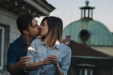 Young couple celebrating with sparkler