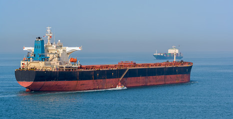 Obraz premium Pilot boat and bulk carrier cargo ship