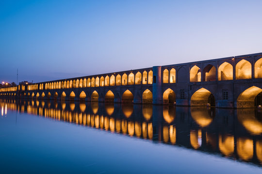 Si-o-seh-pol bridge reflecting in zayandeh river at night, esfahan, Iran