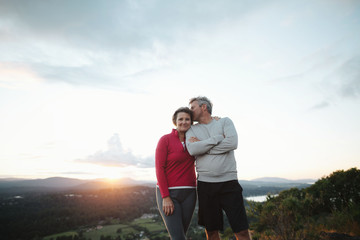Fit, active middle age couple hiking together at sunset