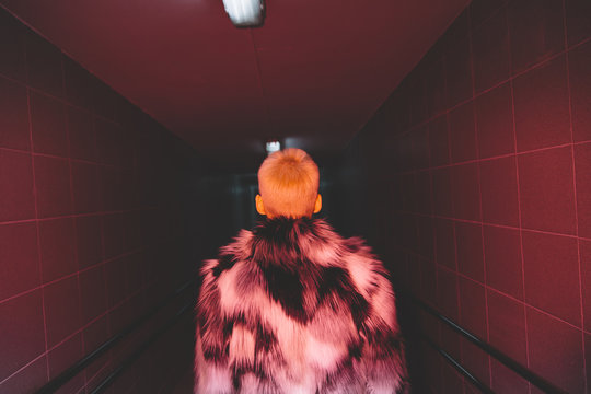 Rear view of woman with fur jacket walking in subway