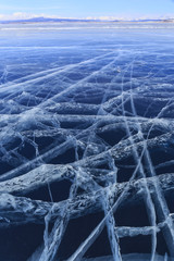 Ice covered with cracks in the background of mountains