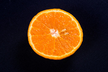 orange tangerine half sliced on black background. Isolated Fresh orange in Top flat view.