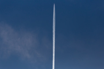 jet with contrails on blue sky high above