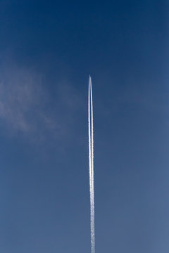 jet with contrails on blue sky high above