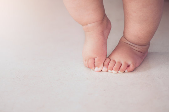 Small baby feet doing the first step on the floor