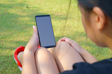 Female hand holding the smartphone Black and Green nature