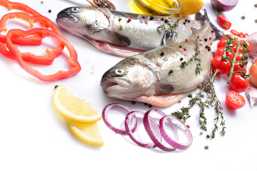 Fish trout with spices and vegetables on a white background