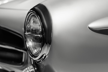Vintage car headlight close up. Old luxury car classic design. Black and white colors