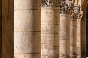 Colonnade - row of old rough stone corinthian columns, with decorative tops - receding perspective