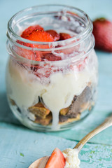 Dessert in a jar: strawberry with cream and biscuit
