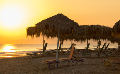 Пляжные зонтики на фоне восхода солнца 1 - obrazy, fototapety, plakaty