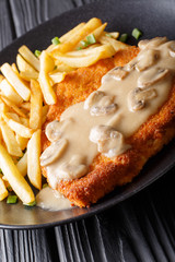 Jaeger Viennese schnitzel with French fries and mushrooms close-up. vertical