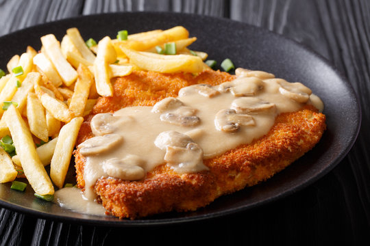 Traditional hunter schnitzel with sauce and fries close-up on a plate. horizontal