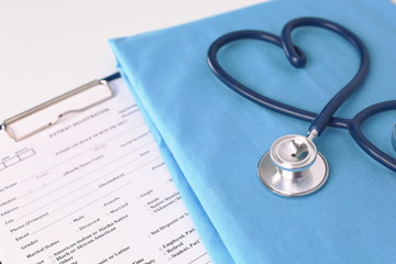 A stethoscope shaping a heart on a medical uniform, closeup