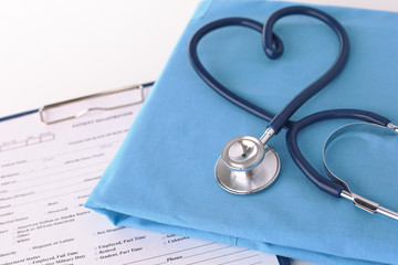 A stethoscope shaping a heart on a medical uniform, closeup