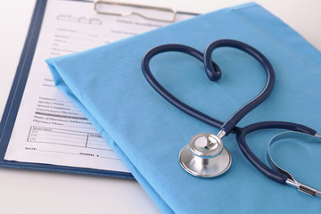 A stethoscope shaping a heart on a medical uniform, closeup